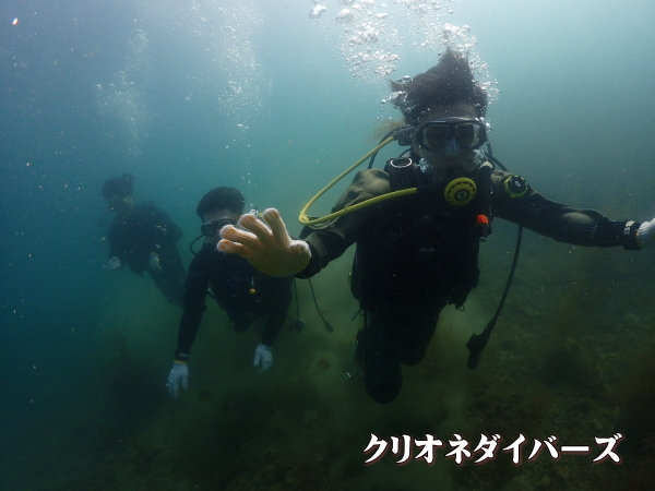 水中カメラに向かって余裕のピースサインをする体験ダイビングのゲスト様
