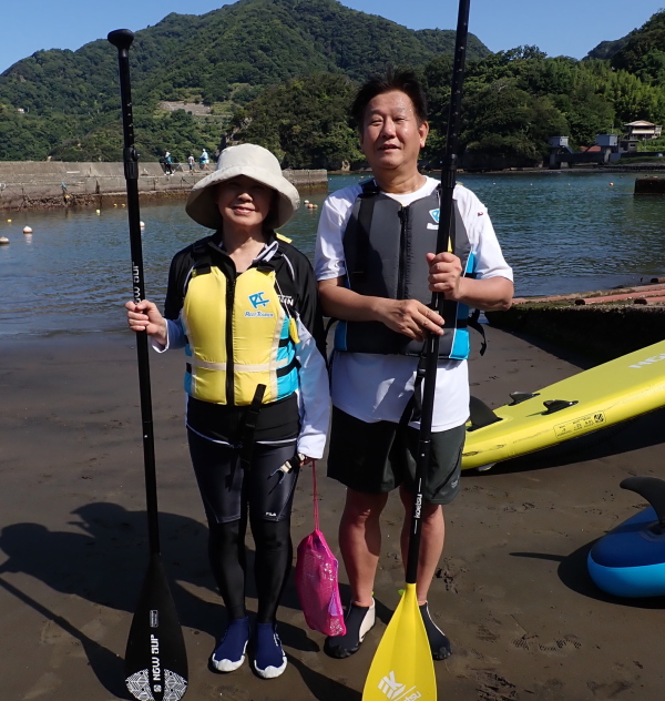 波の穏やかな大田子海岸でSUPを楽しむ笑顔のご夫婦