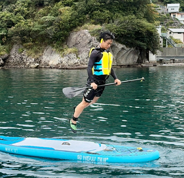 SUPボードの上で両足ジャンプして見事着地する参加者